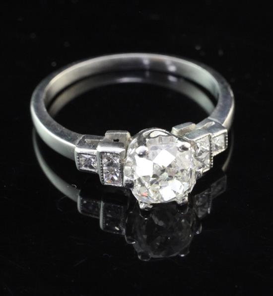 A white gold and single stone cushion cut diamond ring with diamond set shoulders, size N.